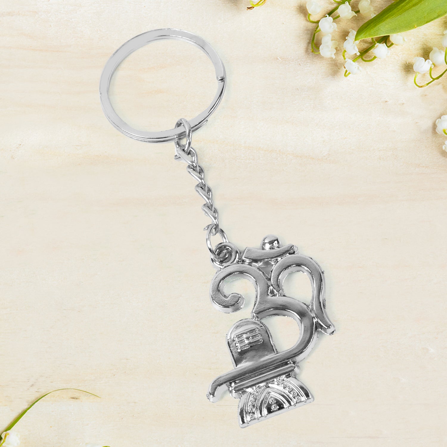 Metal keychain featuring Om symbol and Shivling design by Wukusy, attached to a keyring with detailed craftsmanship.