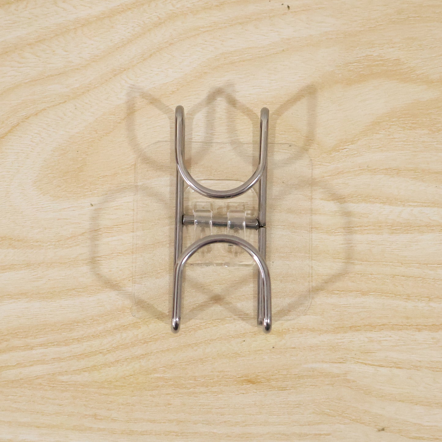 Transparent double loop adhesive wall hook by Wukusy, showing a clear plastic hook with dual loops attached to a wall.