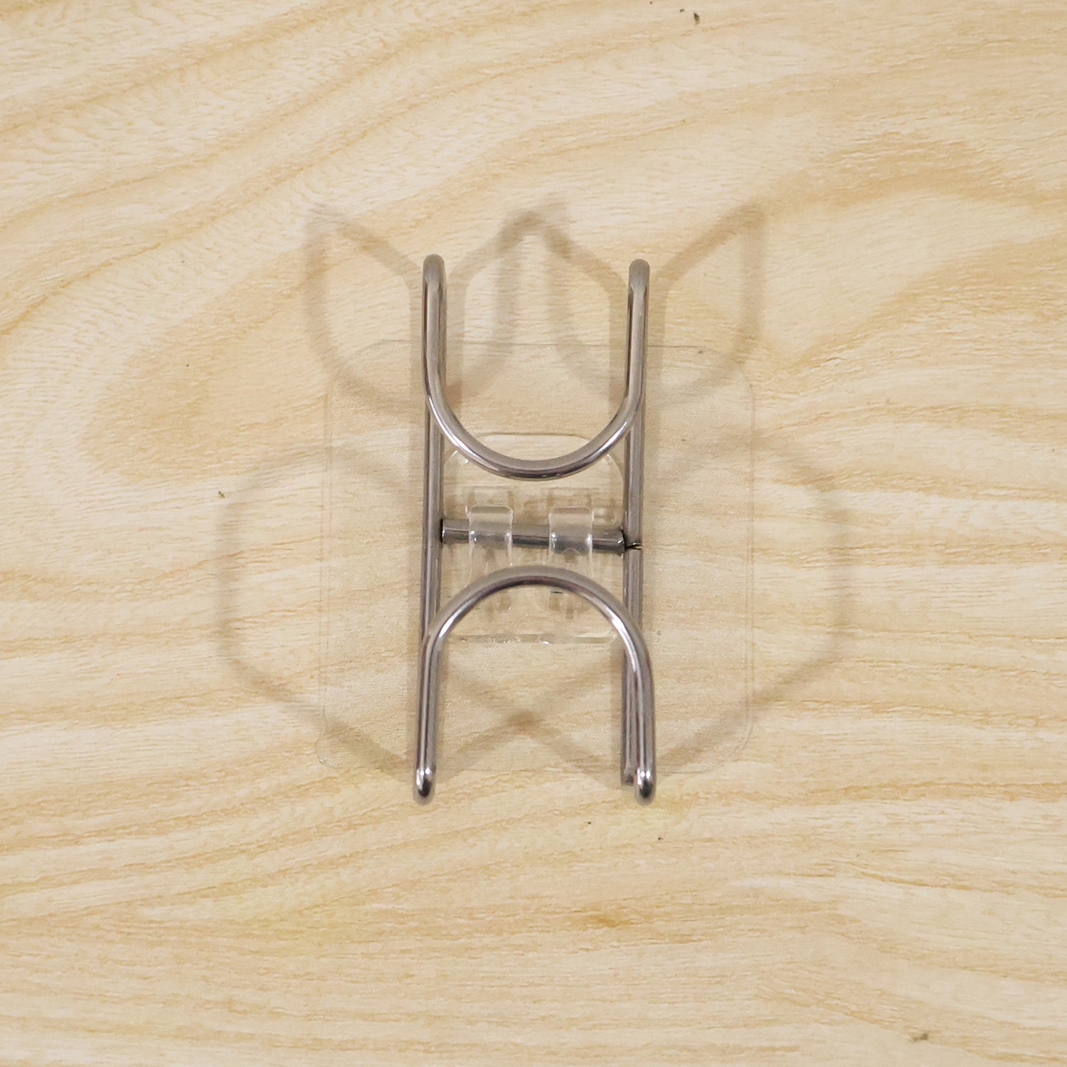 Transparent double loop adhesive wall hook by Wukusy, showing a clear plastic hook with dual loops attached to a wall.