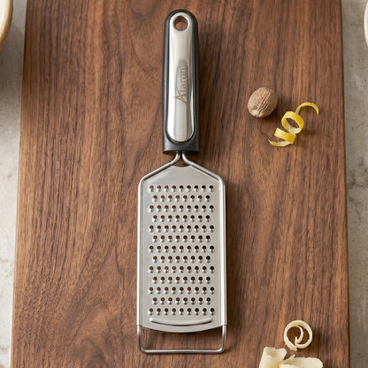 Wukusy SS slim cheese grater with plastic handle, ideal for vegetables and lemon zest, shown with grated produce.
