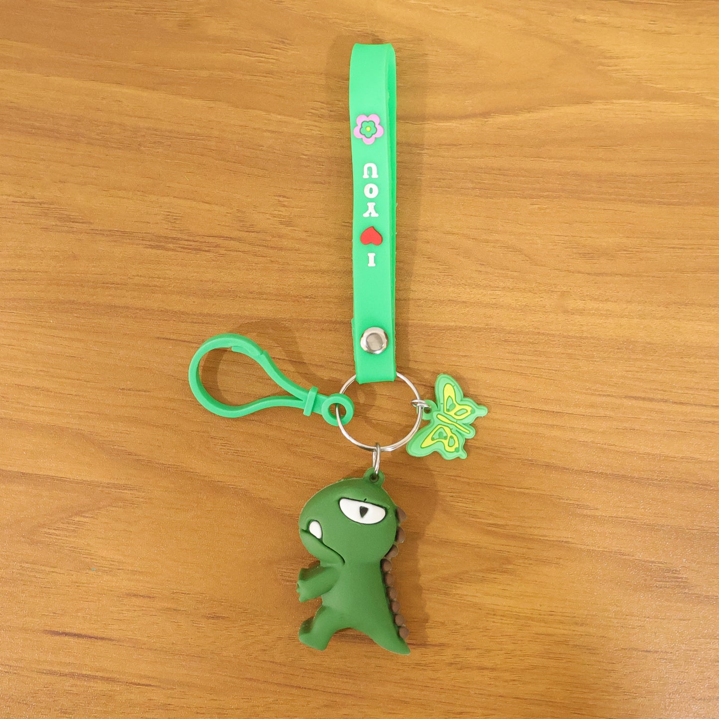 Cute dinosaur cartoon keychain with silicone strap from Wukusy, featuring a colorful, playful dinosaur design on a durable keyring.