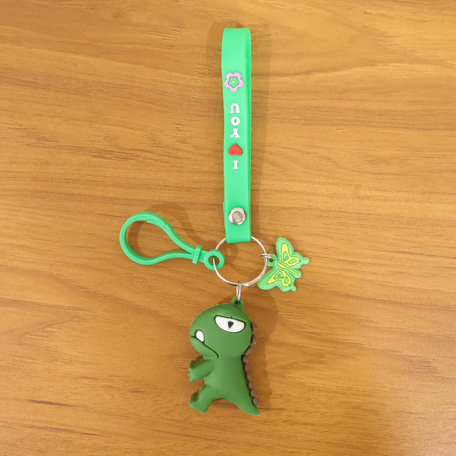 Cute dinosaur cartoon keychain with silicone strap from Wukusy, featuring a colorful, playful dinosaur design on a durable keyring.