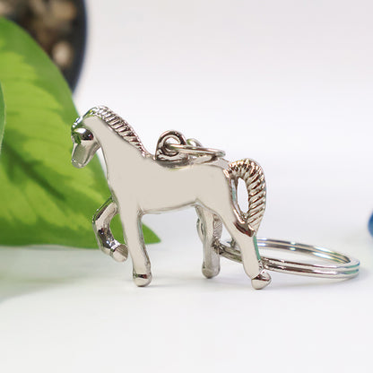 Shiny metallic horse-shaped keychain from Wukusy with intricate horse design on a silver finish.