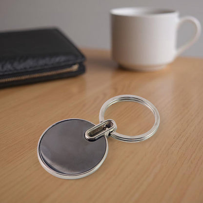 Black round metal keychain from Wukusy featuring a sleek, minimalist design with a smooth finish and sturdy keyring.