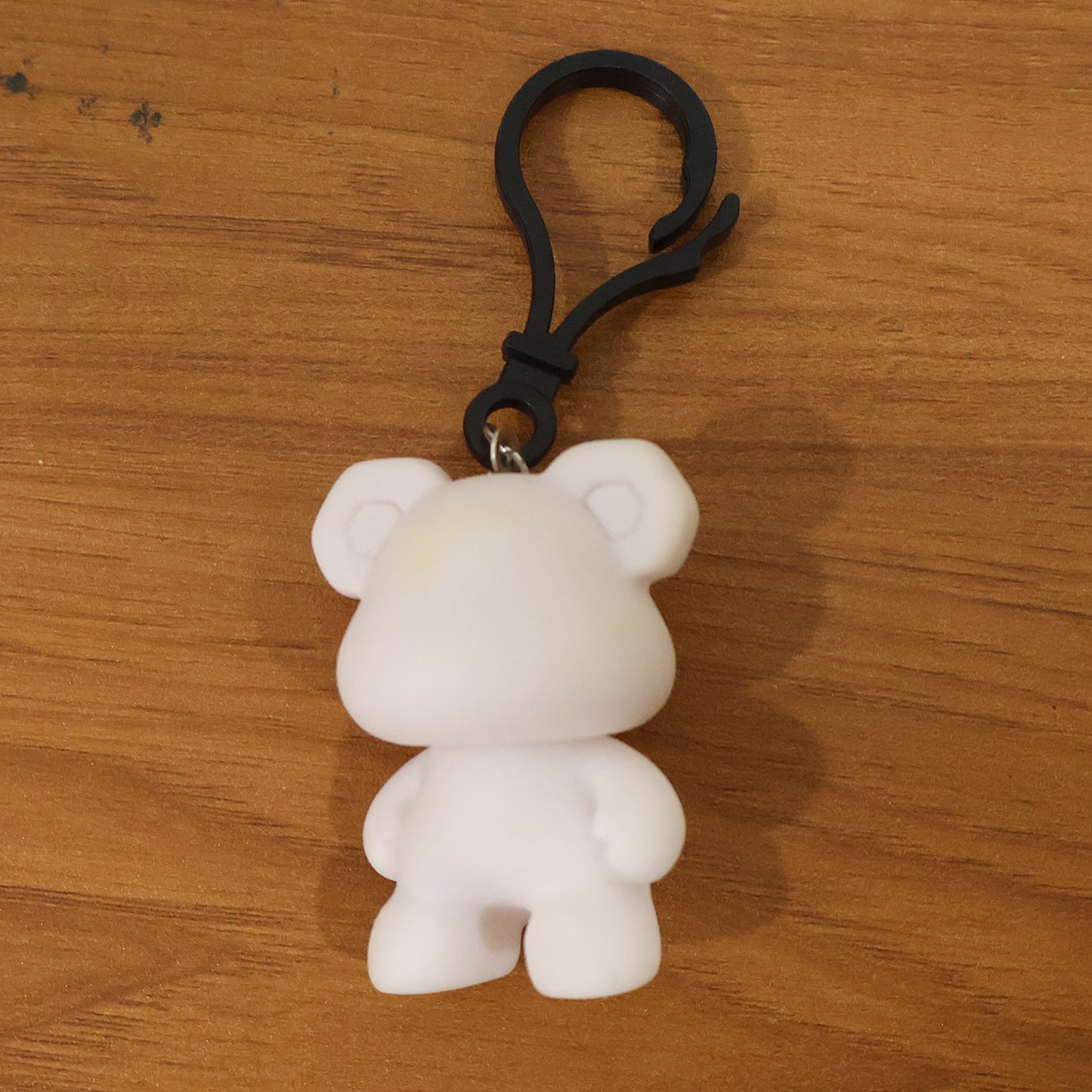 Wukusy cute bear figure keychain featuring a small, plush-style bear with detailed facial features and a keyring attachment.