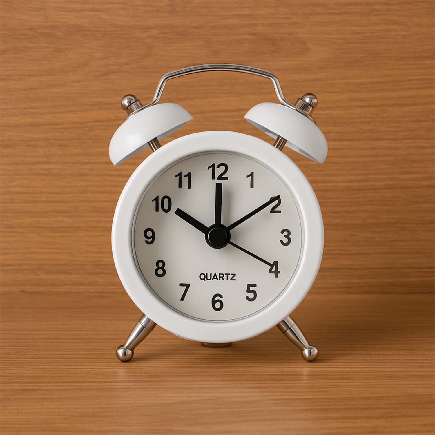 Small Wukusy twin-bell analog alarm clock with classic design, metal bells, and a round white face showing black numbers.