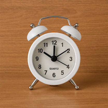 Small Wukusy twin-bell analog alarm clock with classic design, metal bells, and a round white face showing black numbers.
