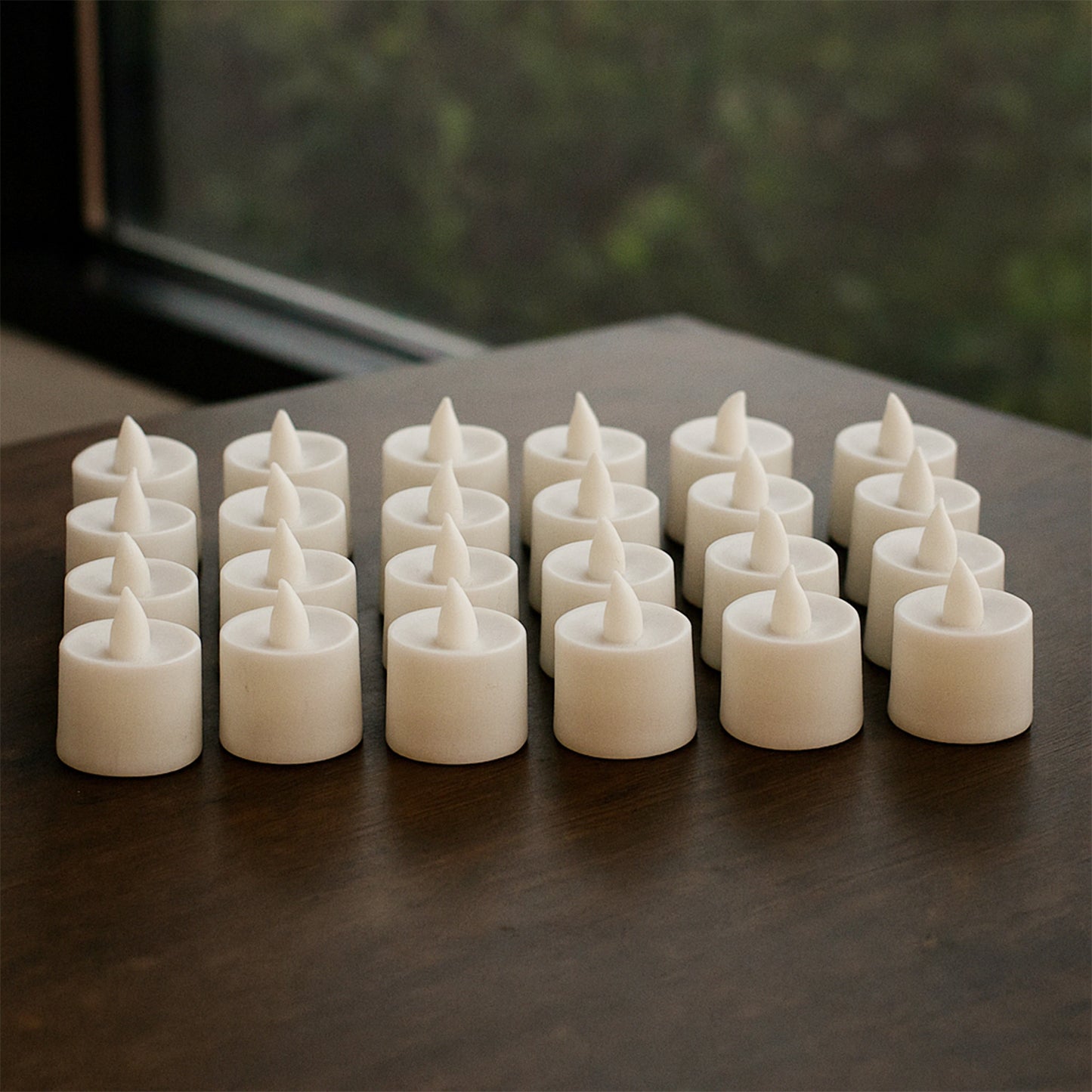 Set of 24 blue LED tea light candles by Wukusy, showing small, battery-operated candles with a soft glowing light.