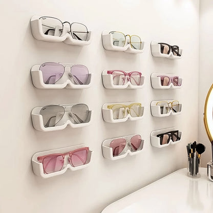 Wukusy wall mount adhesive sunglass holder, single black plastic clip with adhesive backing for organizing sunglasses on wall.