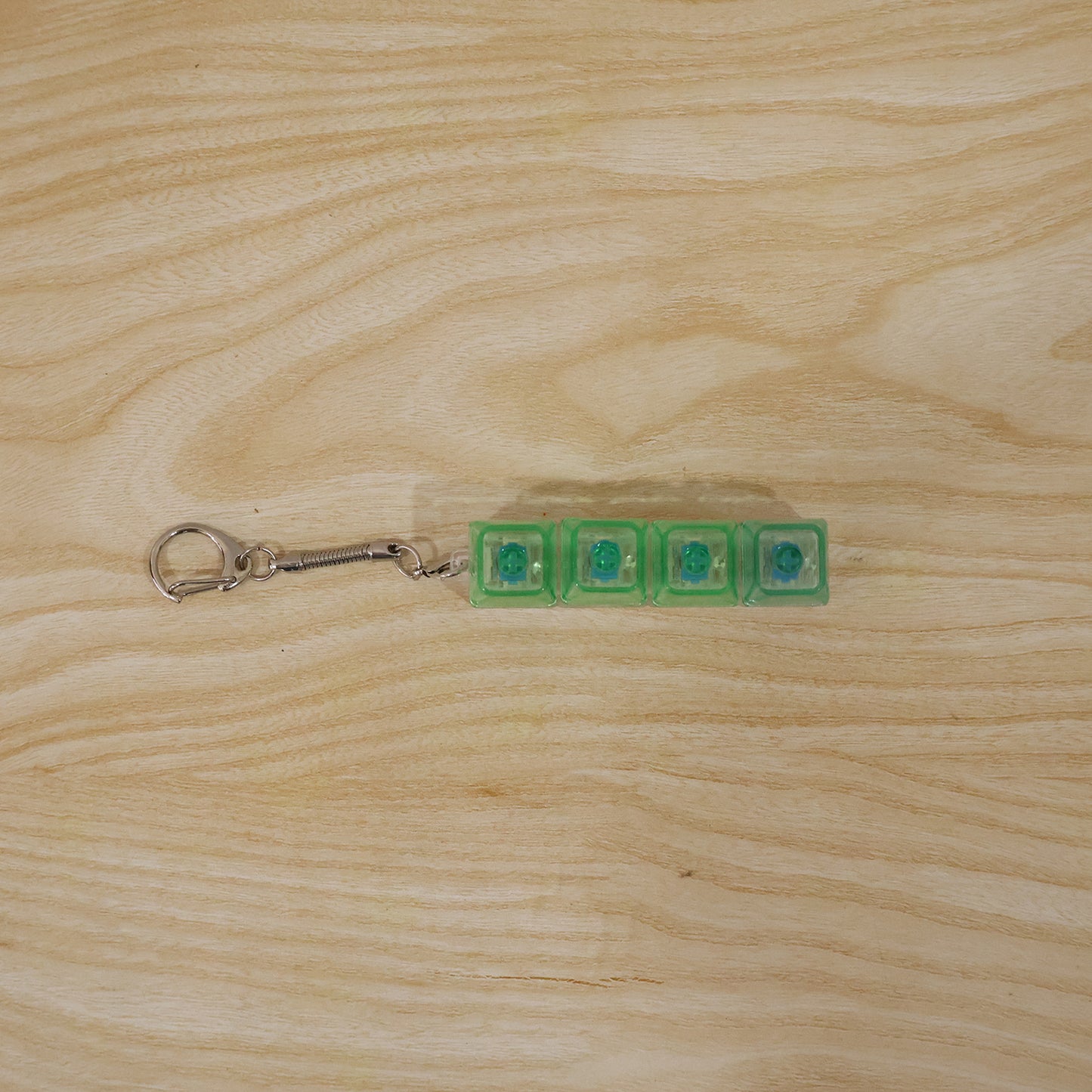 Wukusy mechanical keyboard switch keychain featuring a miniature mechanical switch with clear housing and colorful internal components.