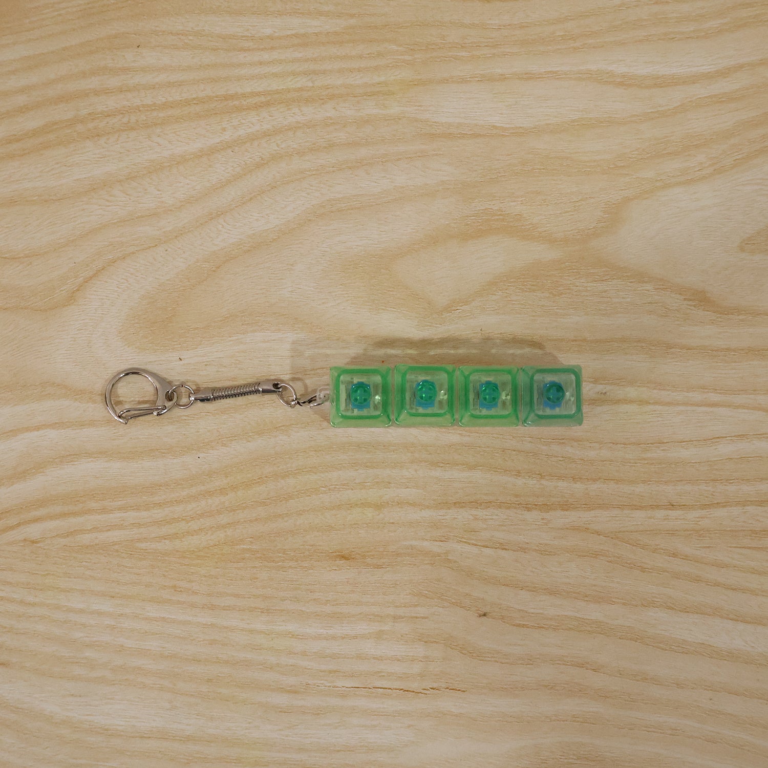 Wukusy mechanical keyboard switch keychain featuring a miniature mechanical switch with clear housing and colorful internal components.