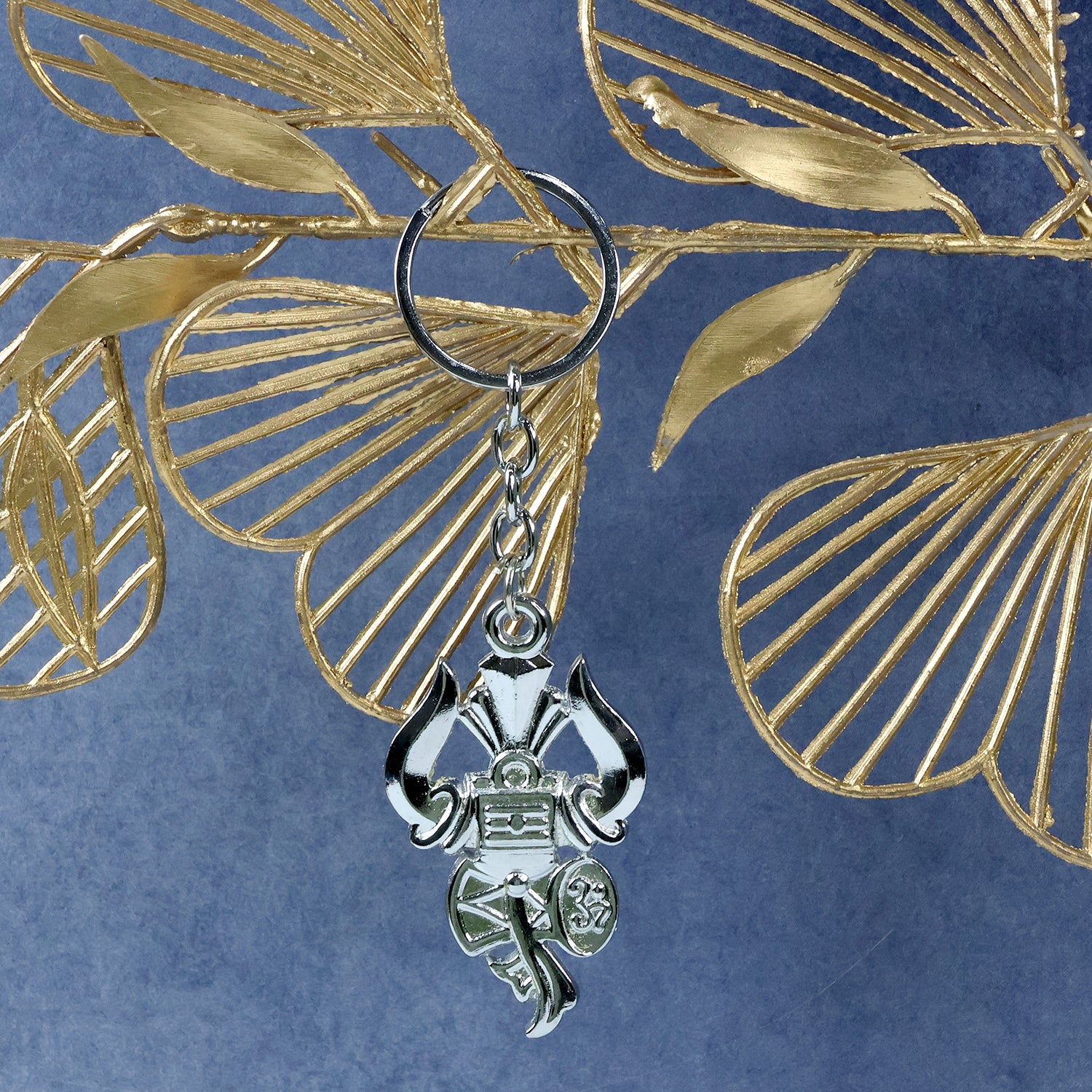 Silver keychain featuring Trishul, Damru, and Shiv symbol from Wukusy, crafted in detailed metallic design.