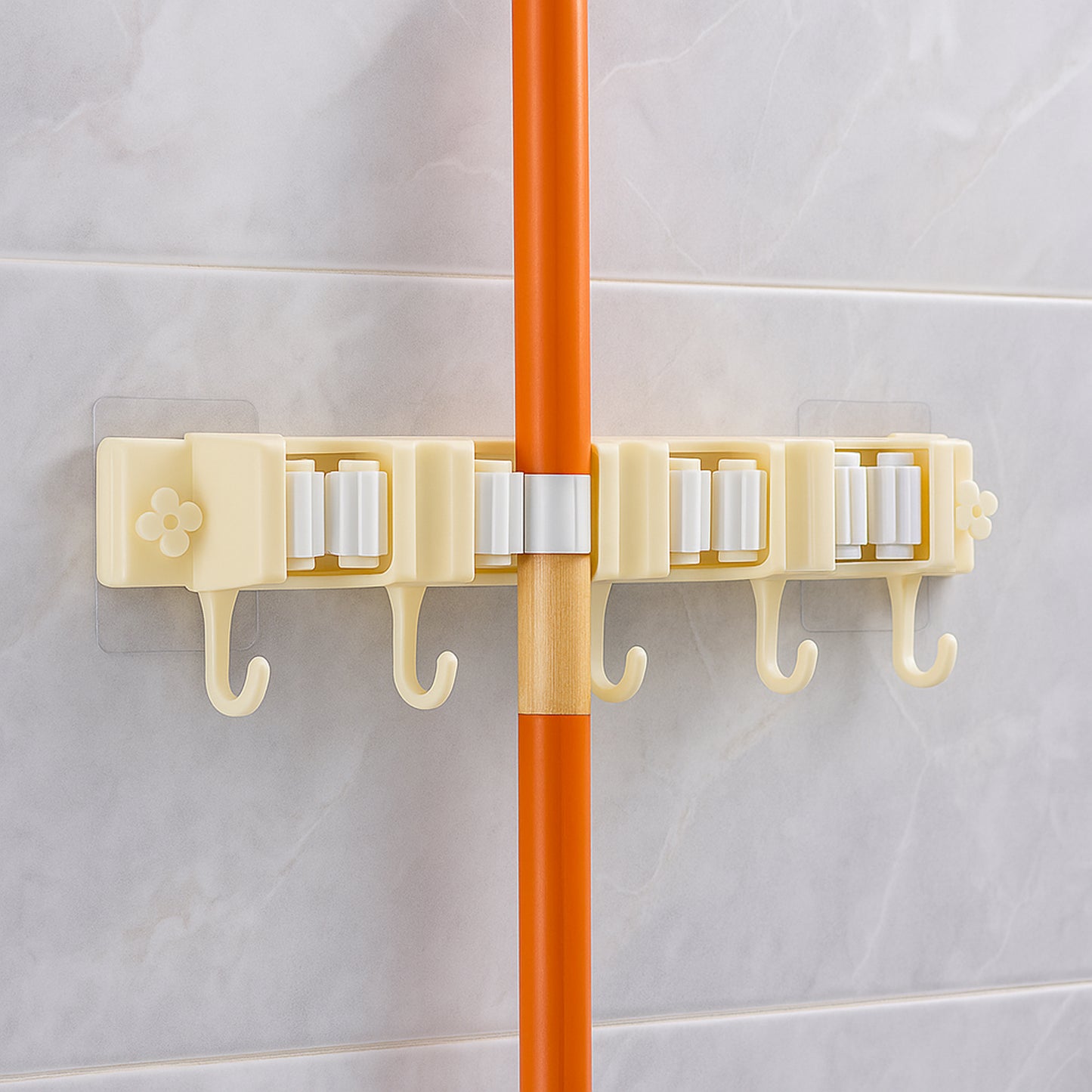 Wukusy self-adhesive wall-mount broom and mop holder rack attached to a wall in a home improvement setting.