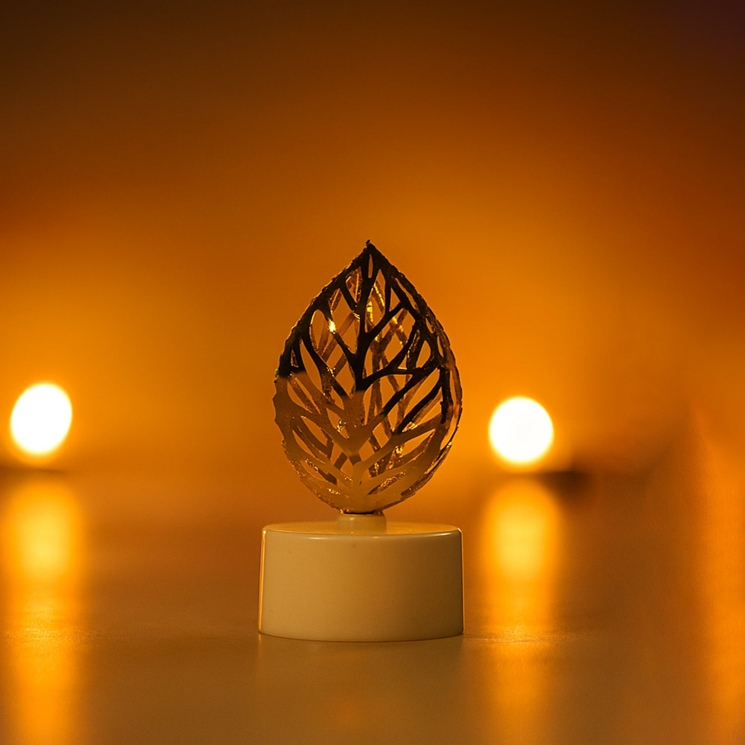 Set of 12 golden leaf-shaped flameless LED candles for home decor by Wukusy, featuring intricate leaf designs and warm LED lighting.