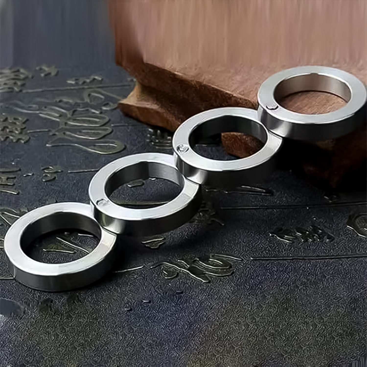 Portable Wukusy 4-finger rotating folding travel ring set displayed with open and closed positions on a white background.