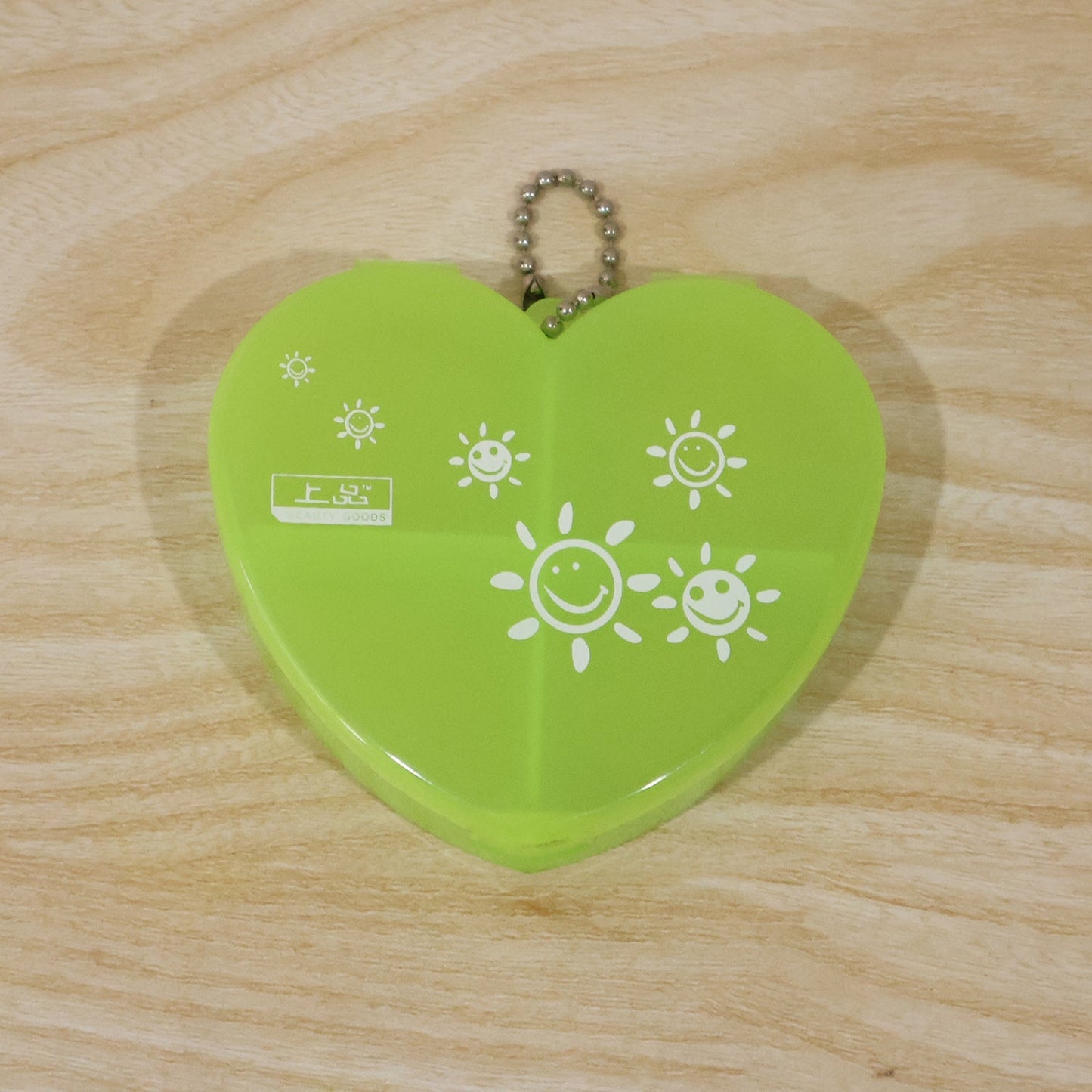 Heart-shaped plastic pill organizer box with four compartments and keychain, designed for easy medication storage by Wukusy