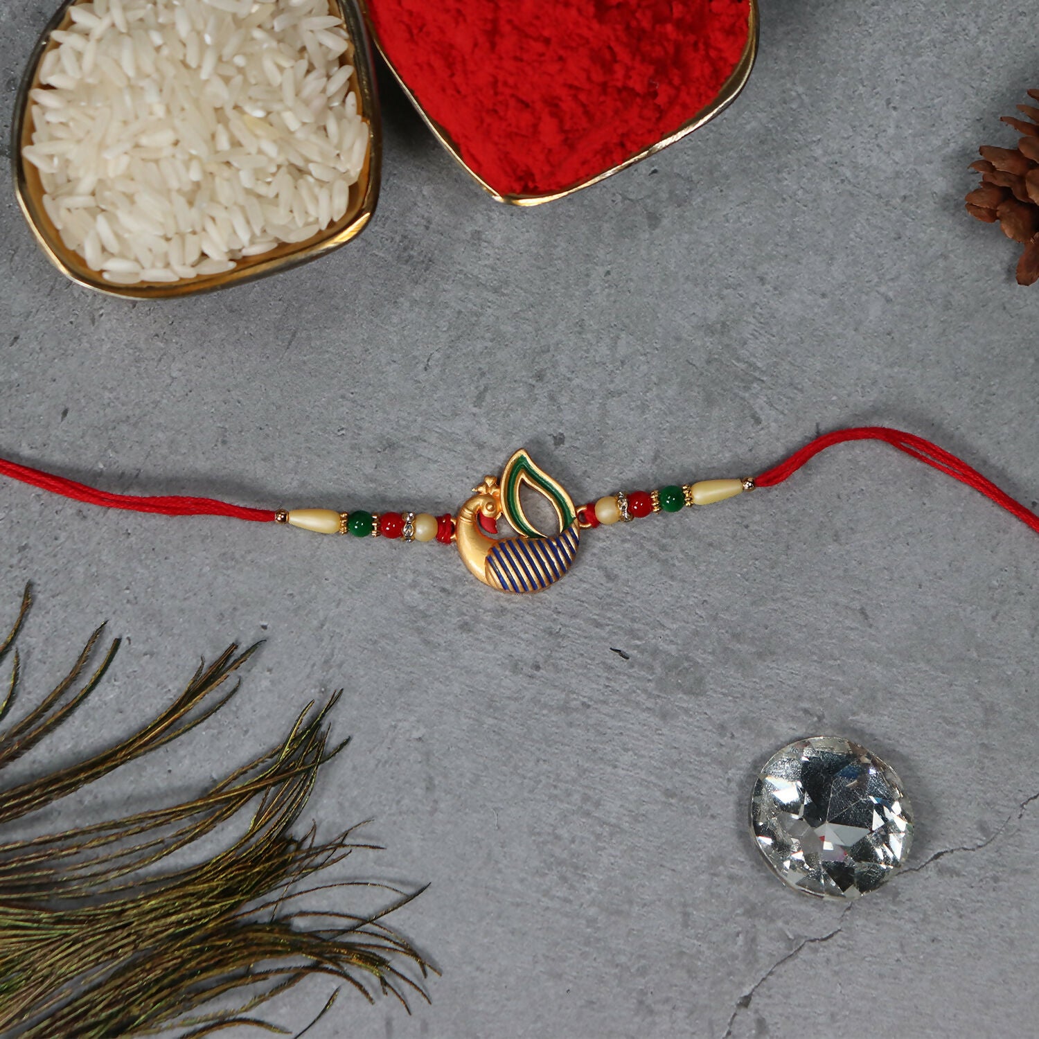 Colorful peacock feather rakhi from Wukusy, featuring intricate design with vibrant feathers for festive occasions.