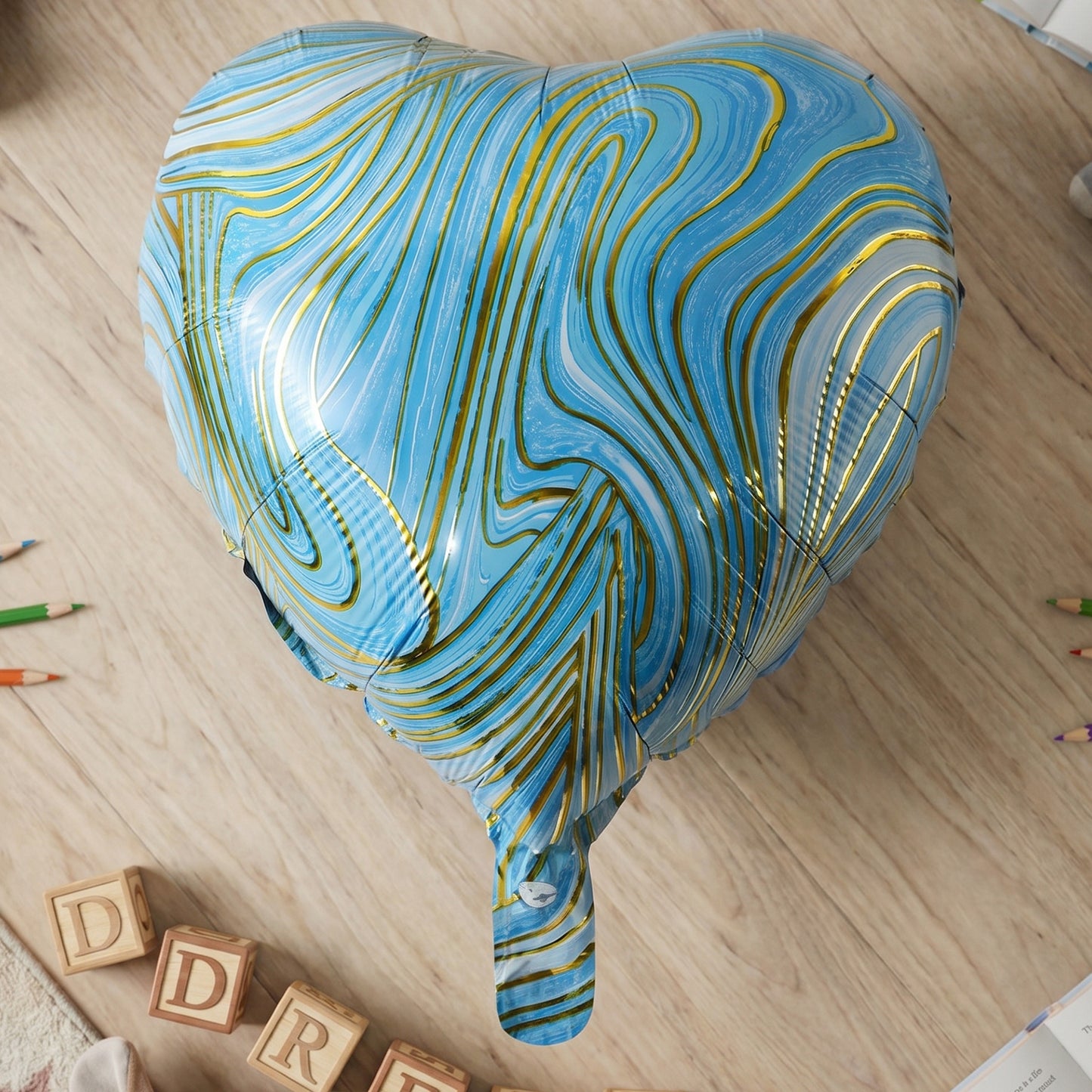 Blue marble heart foil party balloon by Wukusy, inflated, shiny, with a heart shape and colorful marble pattern.