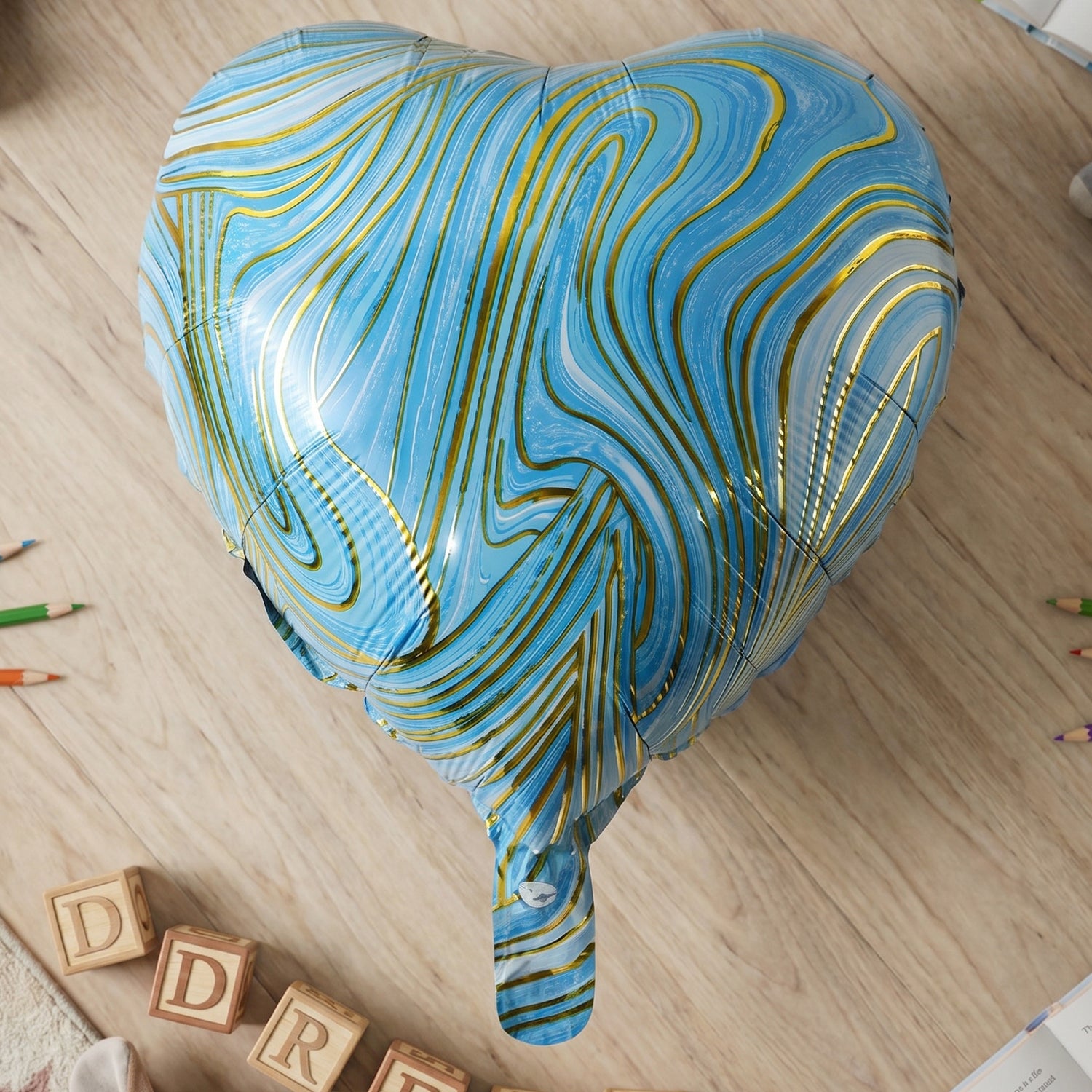 Blue marble heart foil party balloon by Wukusy, inflated, shiny, with a heart shape and colorful marble pattern.