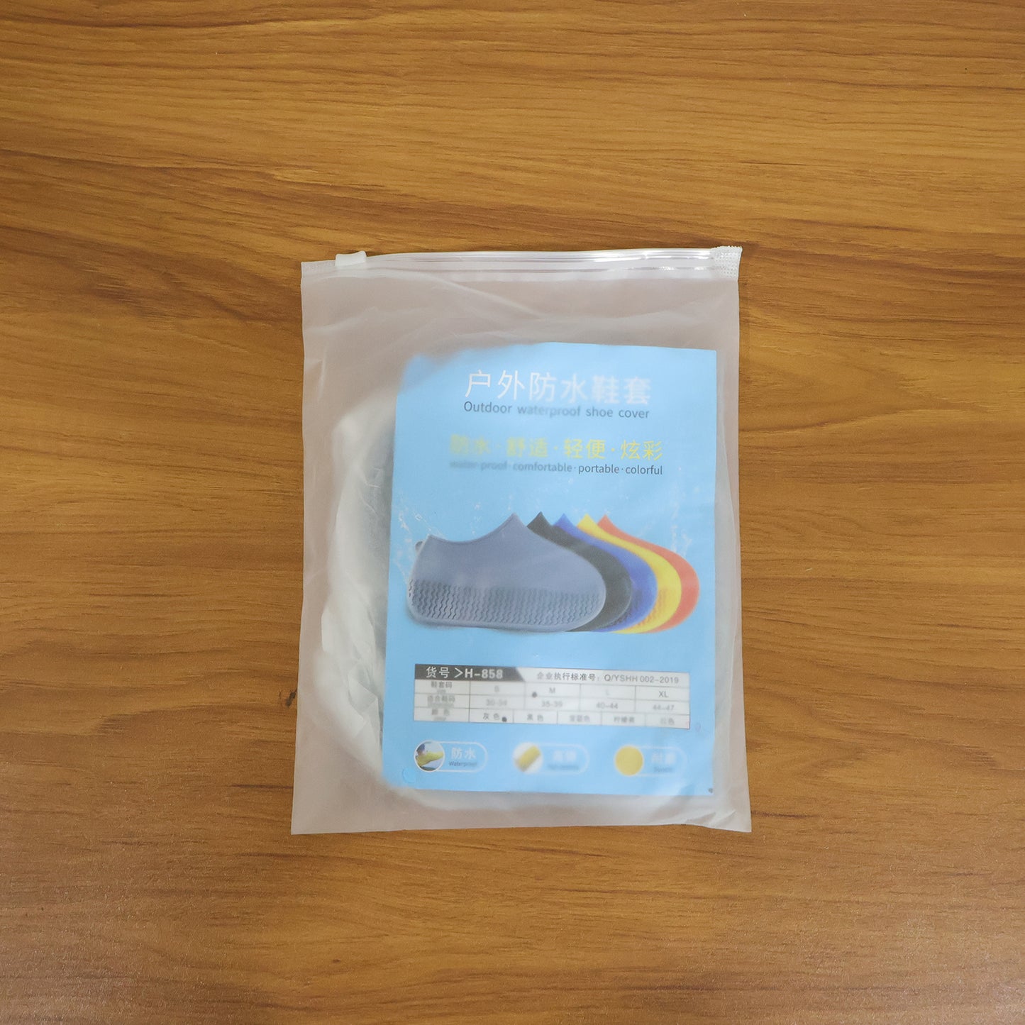 Pair of grey waterproof silicone shoe covers by Wukusy, medium size, designed to protect shoes from rain and moisture.