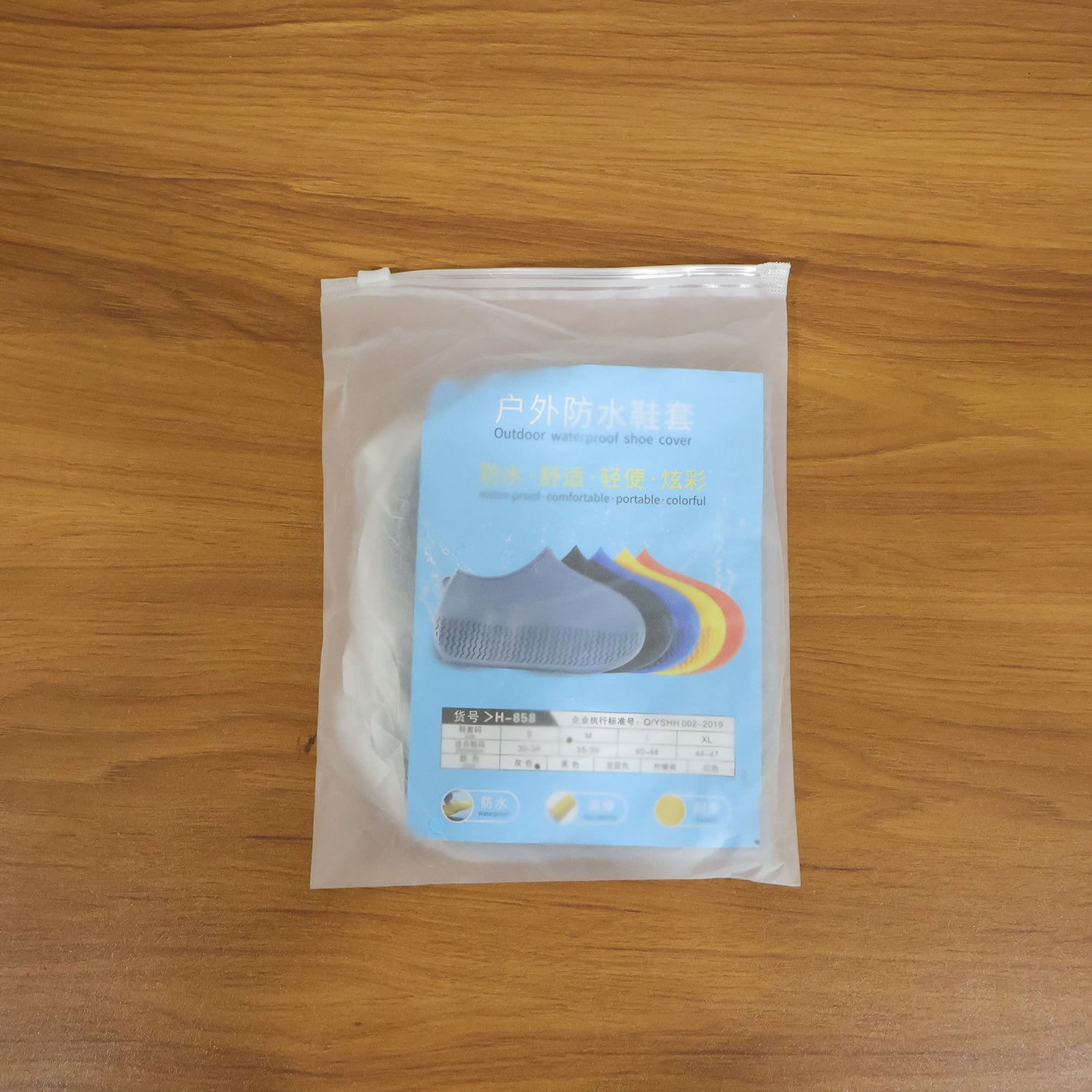 Pair of grey waterproof silicone shoe covers by Wukusy, medium size, designed to protect shoes from rain and moisture.