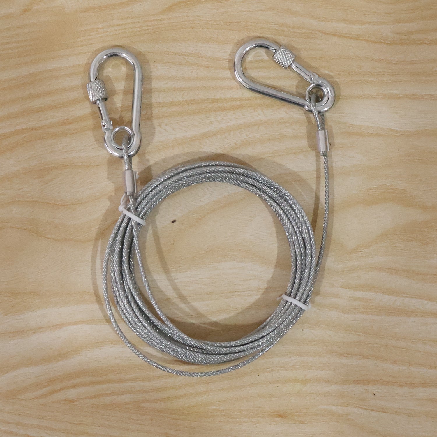 Heavy duty steel wire rope clothesline with 5 meters length and carabiner hooks, suitable for outdoor drying and versatile hanging use.