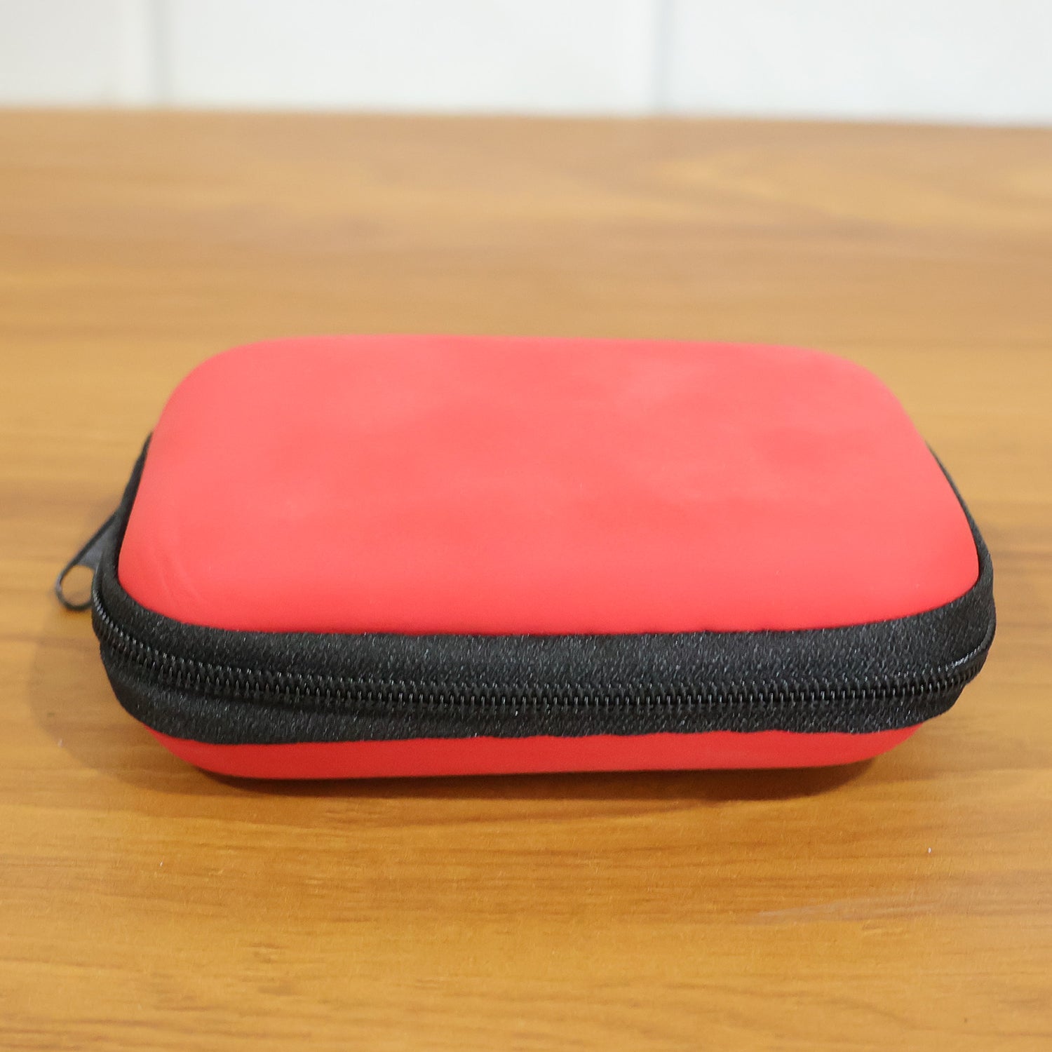 Wukusy premium wired earphones with zipper carry case, shown inside the open case with earphone cable and earbud tips visible.