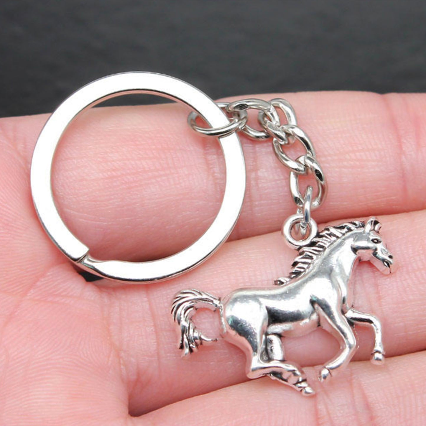 Shiny metallic horse-shaped keychain by Wukusy with detailed horse head design on a silver finish.