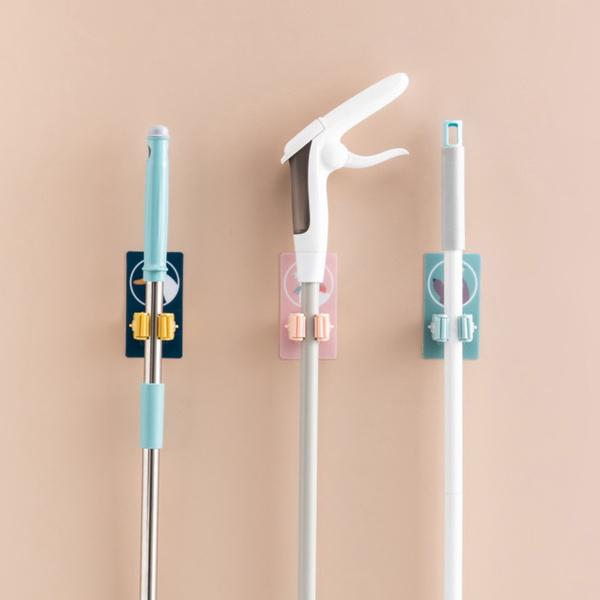 Wukusy 1633 Magic Sticker Series self-adhesive mop and broom holder attached to a wall for home organization.