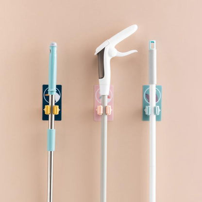 Wukusy 1633 Magic Sticker Series self-adhesive mop and broom holder attached to a wall for home organization.