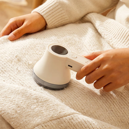 Wukusy rechargeable electric lint remover for clothes, sweaters, sofa, and blankets with a compact design and lint collection chamber.
