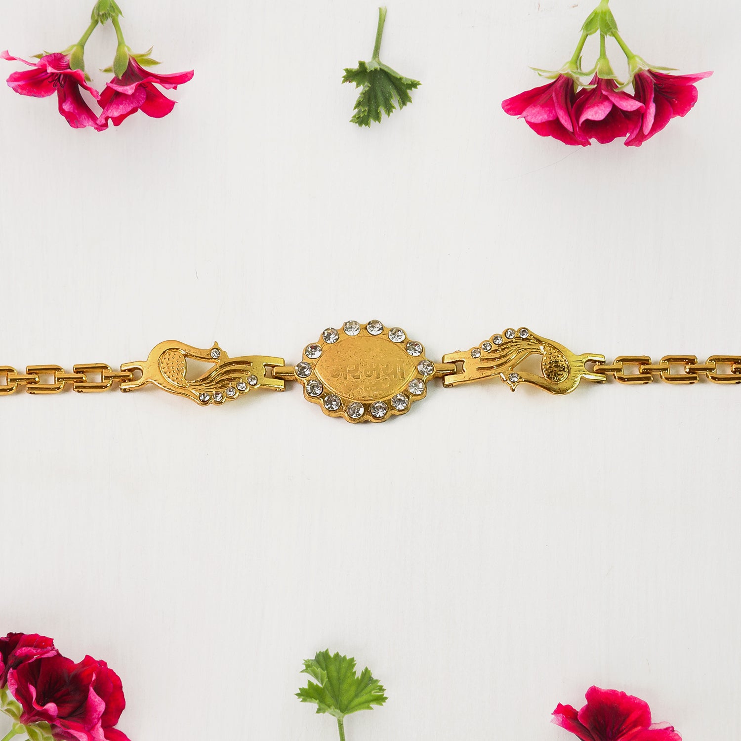 Wukusy Rakhi bracelet with stone border and dual peacock chain ends, featuring intricate design and vibrant craftsmanship.