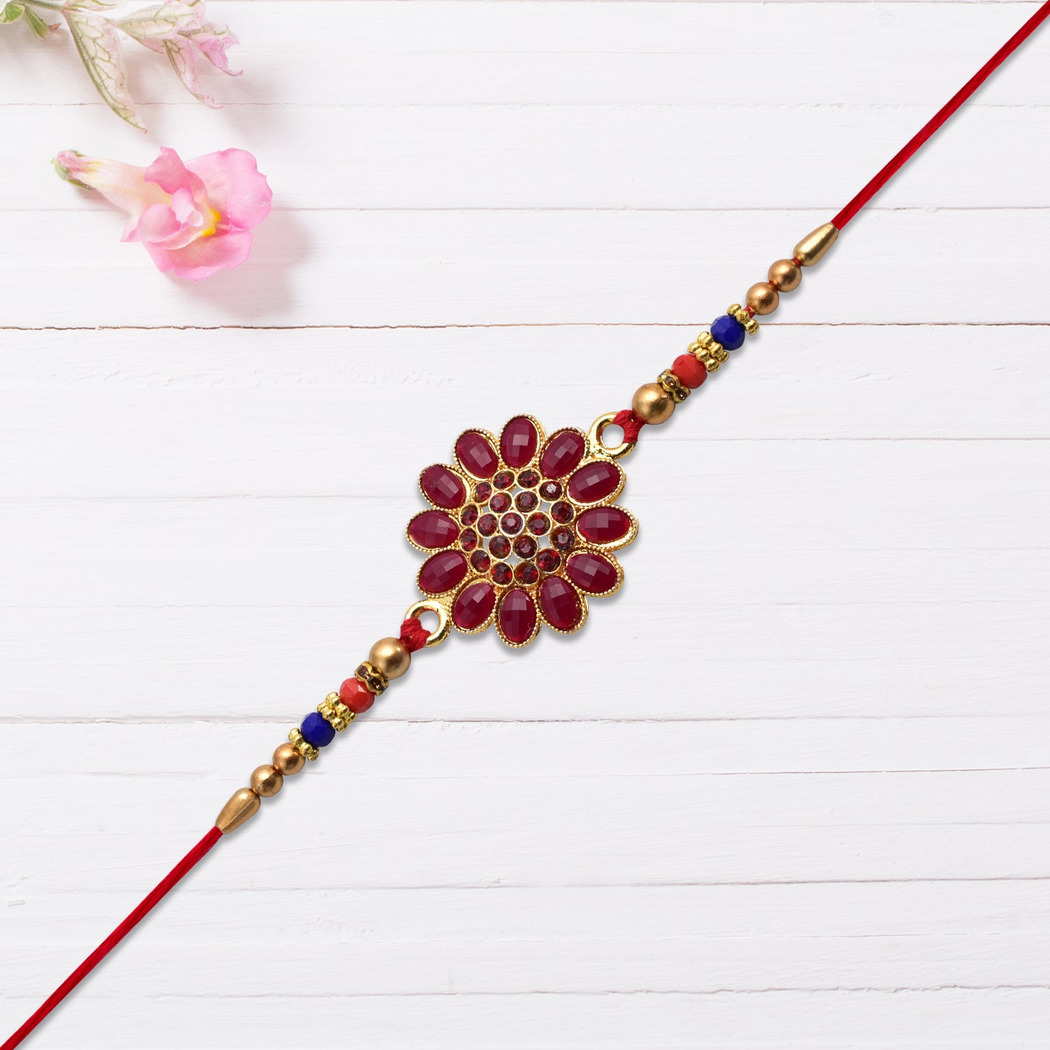 Red floral stone rakhi with bead accents, Wukusy fashion bracelet featuring vibrant floral design and decorative beads.