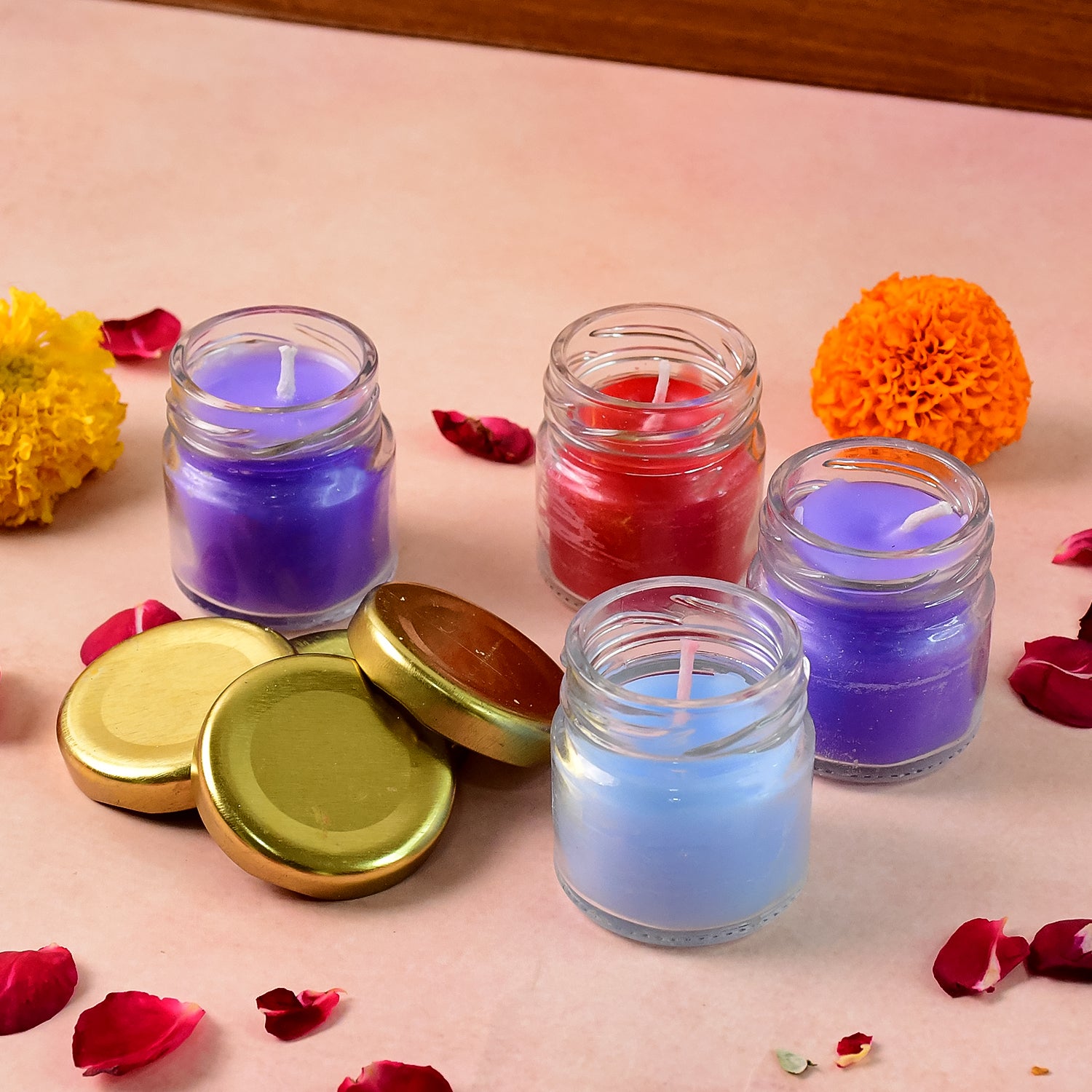 Set of four wax candles in glass jars with gold lids, crafted by Wukusy, perfect for home decor and ambient lighting.