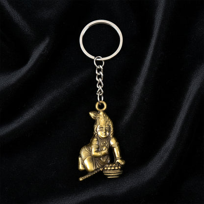Antique-gold Bal Krishna Makhan Chor keychain by Wukusy featuring detailed metal craftsmanship and traditional design.