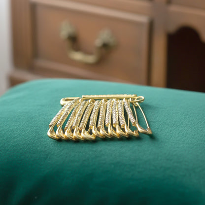 Set of 12 decorative golden safety pin brooches from Wukusy, featuring stylish and shiny accessories for fashion and decoration.