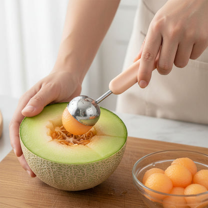 Wukusy 2-in-1 fruit scooper and cutter tool, stainless steel, with ergonomic handle for easy fruit preparation.