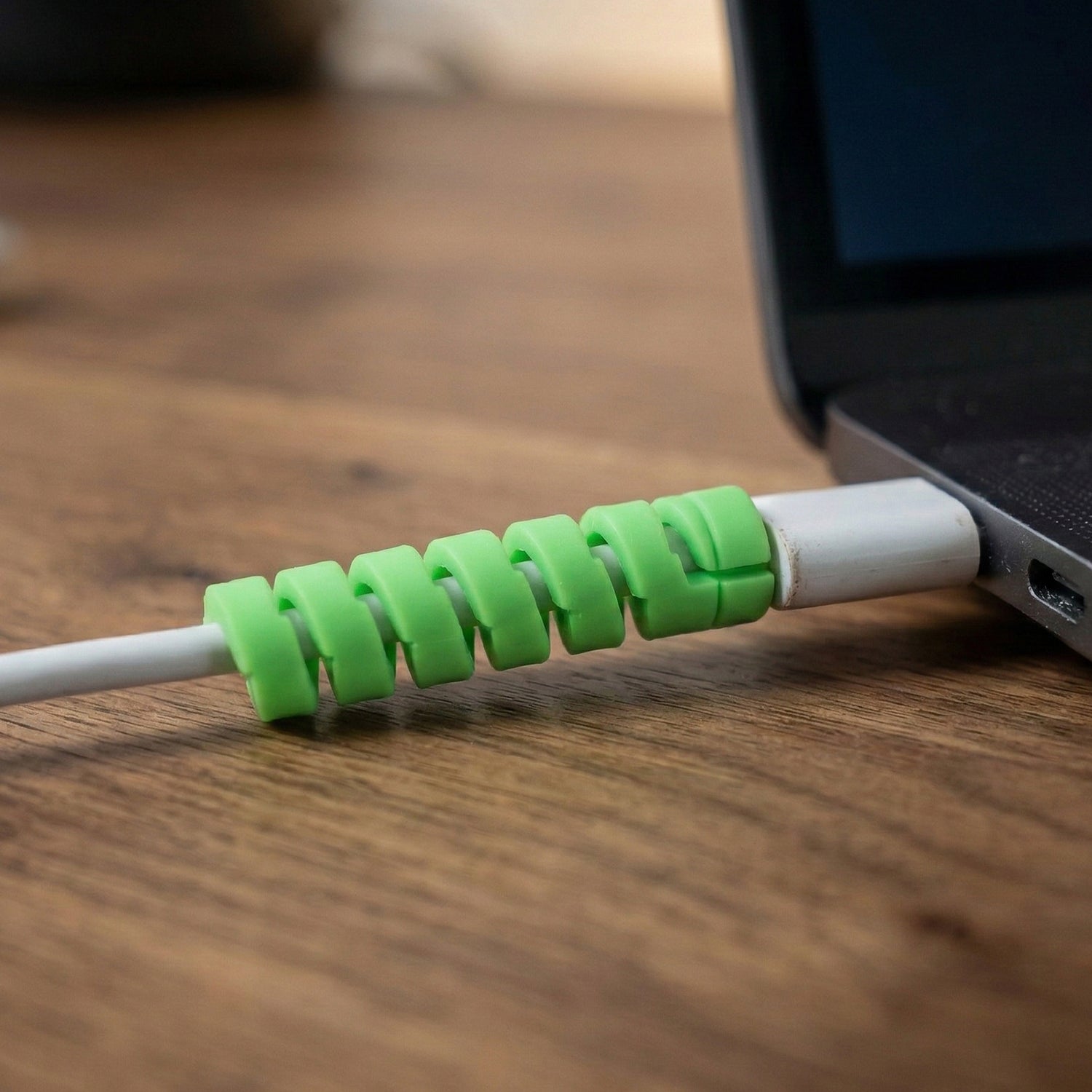 Wukusy spiral cable protector wrapping around a charger cable to prevent damage and fraying.