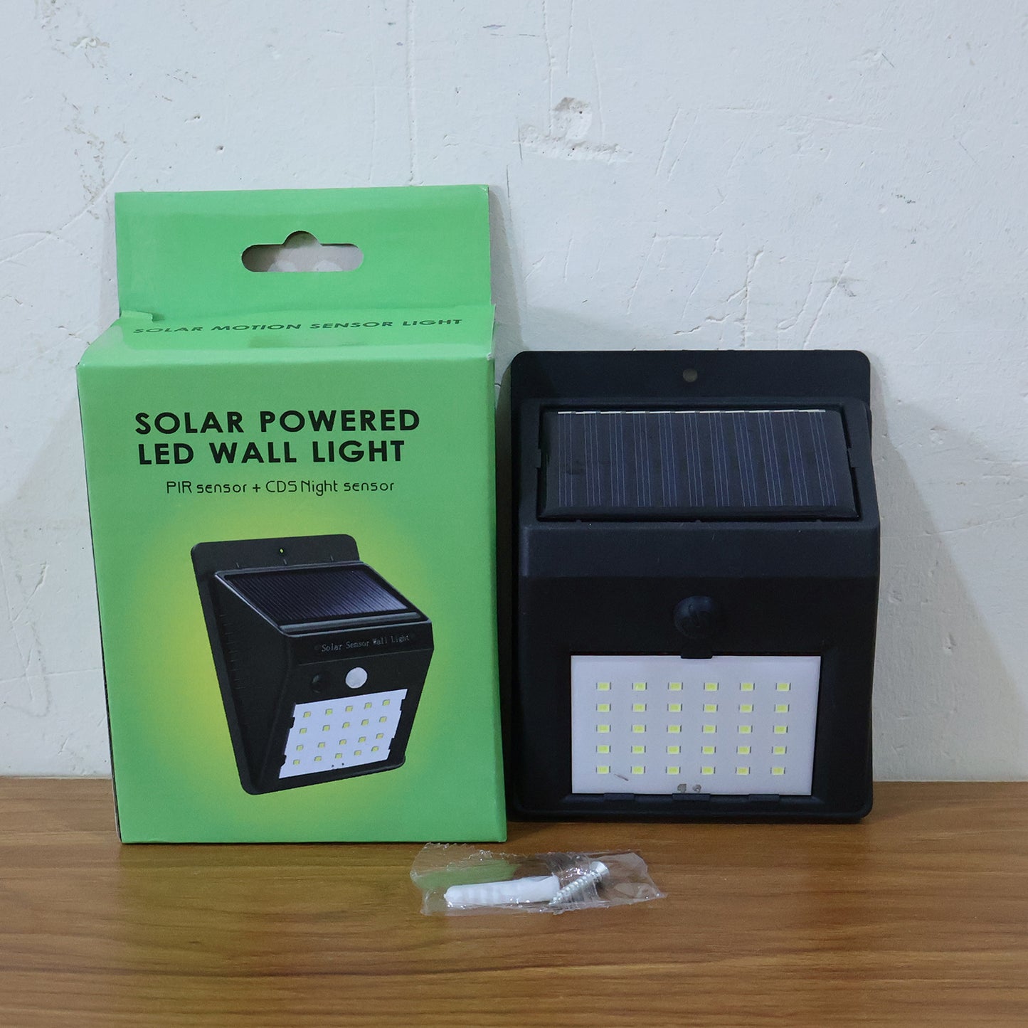 Wukusy solar-powered LED wall light mounted on garden wall, providing outdoor illumination at night