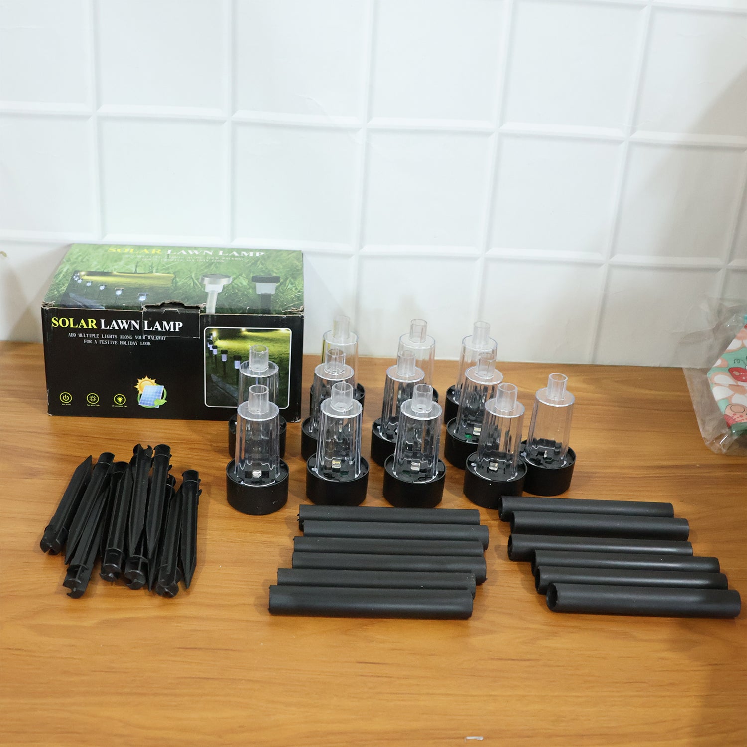 Wukusy solar-powered lawn pathway light set with 12 black stake lights illuminating outdoor garden pathways at dusk
