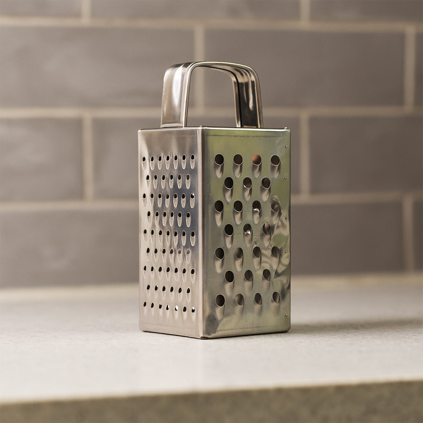 Wukusy Supermom Premium 4-in-1 stainless steel grater and slicer for kitchen use, compact design with multiple grating and slicing options.