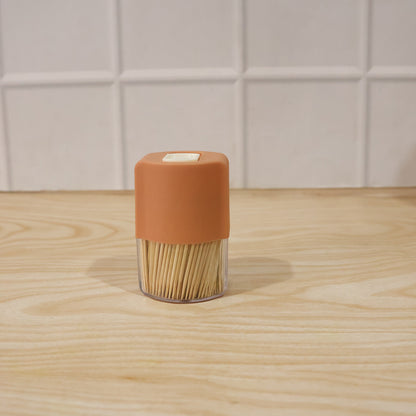 Wukusy toothpick dispenser box set with automatic pop-up holder on a dining table, sleek design for convenient toothpick access.