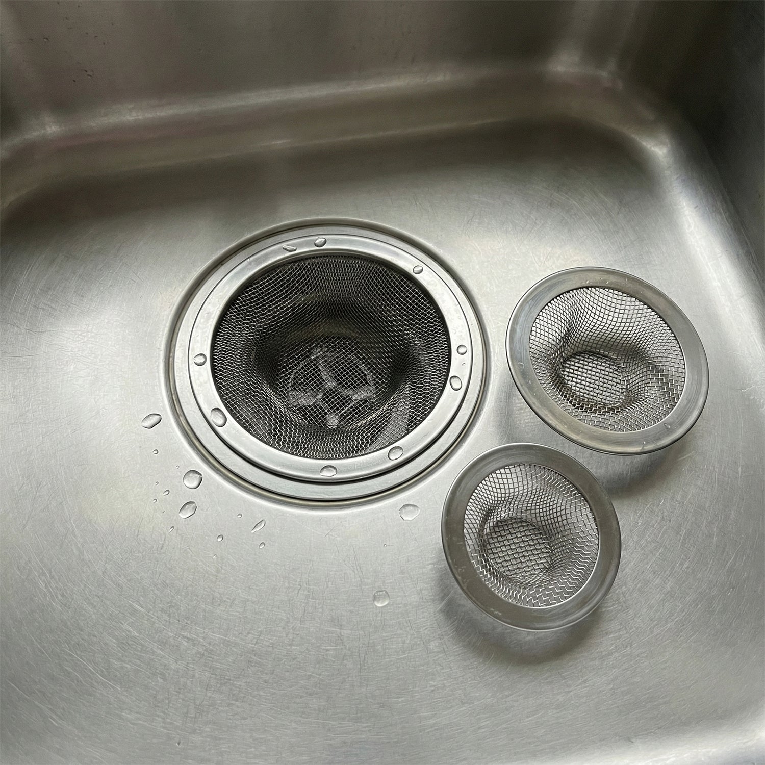 Wukusy stainless steel sink drain strainer set with three round mesh filters for kitchen sink drainage.