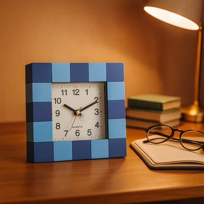 Square quartz table clock by Wukusy showing a sleek, modern design with a clear face and black hour markers on a white background.