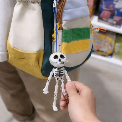 Wukusy hanging skeleton doll keychain featuring a spooky skeleton design, attached to a metal keyring on a plain background.