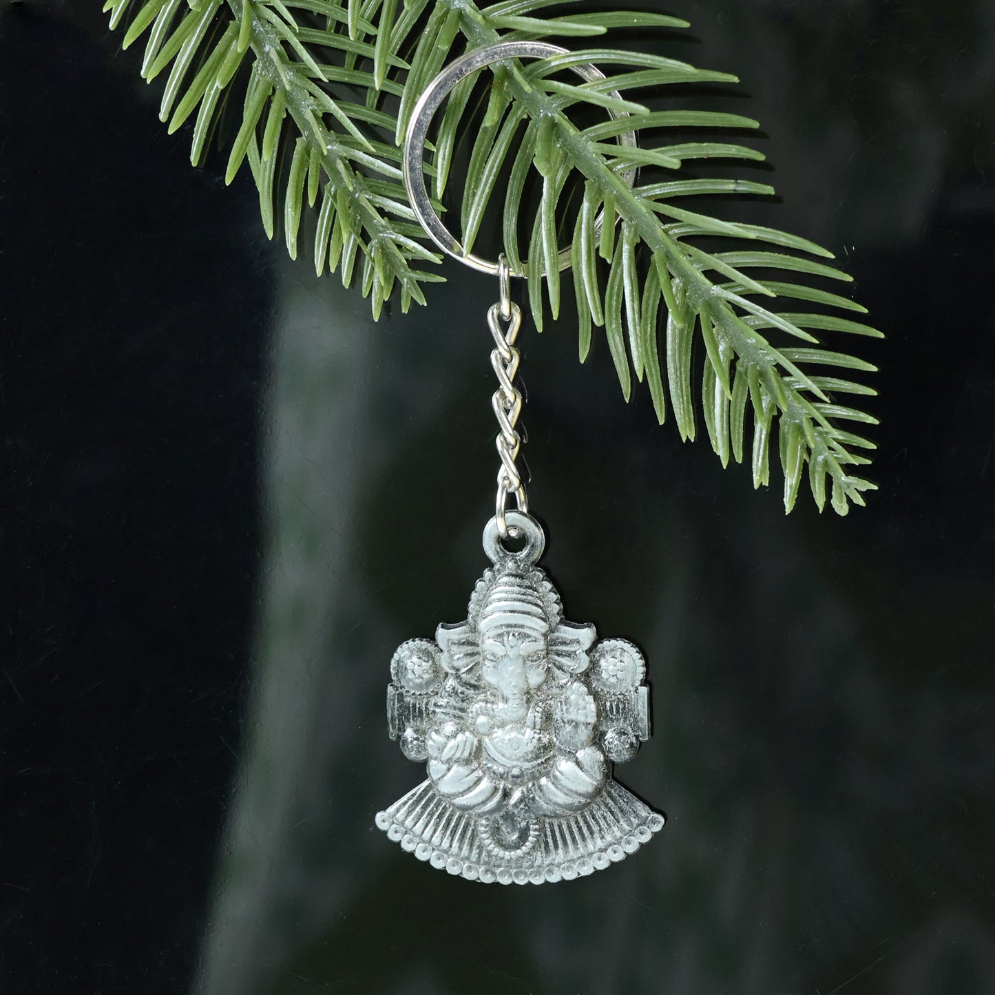 Silver Lord Ganesha sitting design keychain by Wukusy, featuring detailed Ganesha figure on a compact keychain.