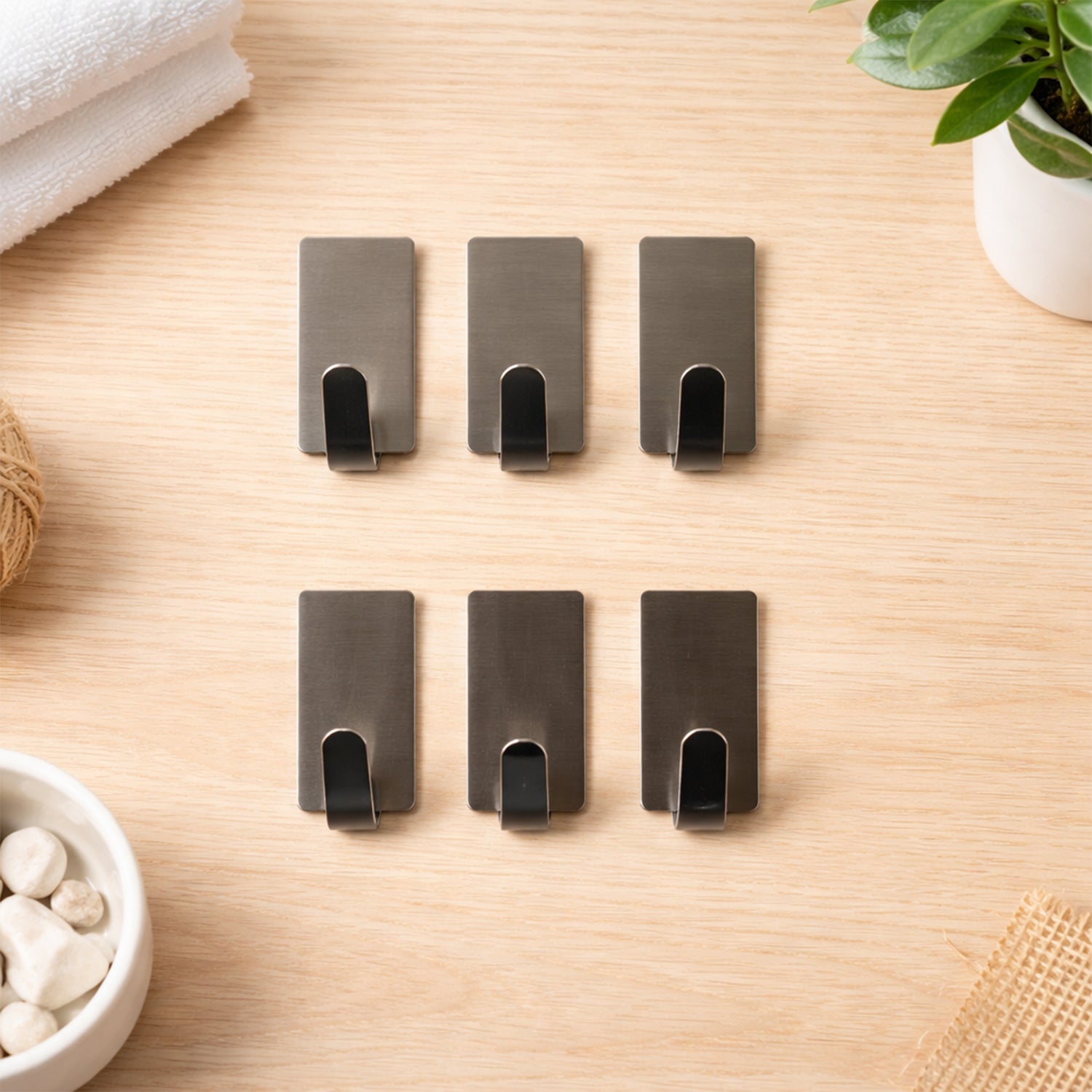 Set of six Wukusy self-adhesive wall hooks attached to a wall, ideal for hanging lightweight items without nails or tools.