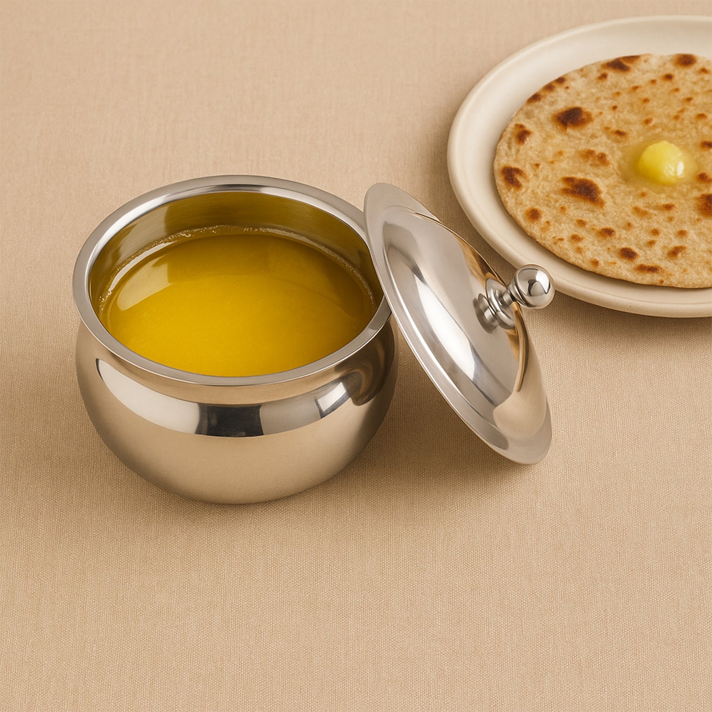 Stainless steel ghee pot with lid from Wukusy, ideal for home kitchen use, featuring a shiny polished finish and ergonomic handle.