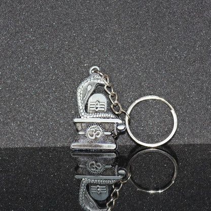 Silver Shivling with snake design keychain by Wukusy, featuring intricate craftsmanship and detailed metallic finish.