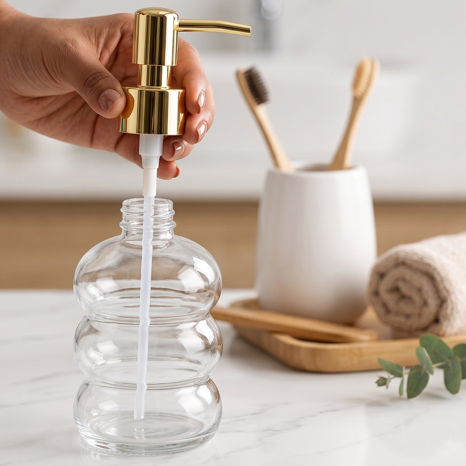 Clear glass liquid soap dispenser with a gold pump from Wukusy, showcasing a sleek and elegant design.